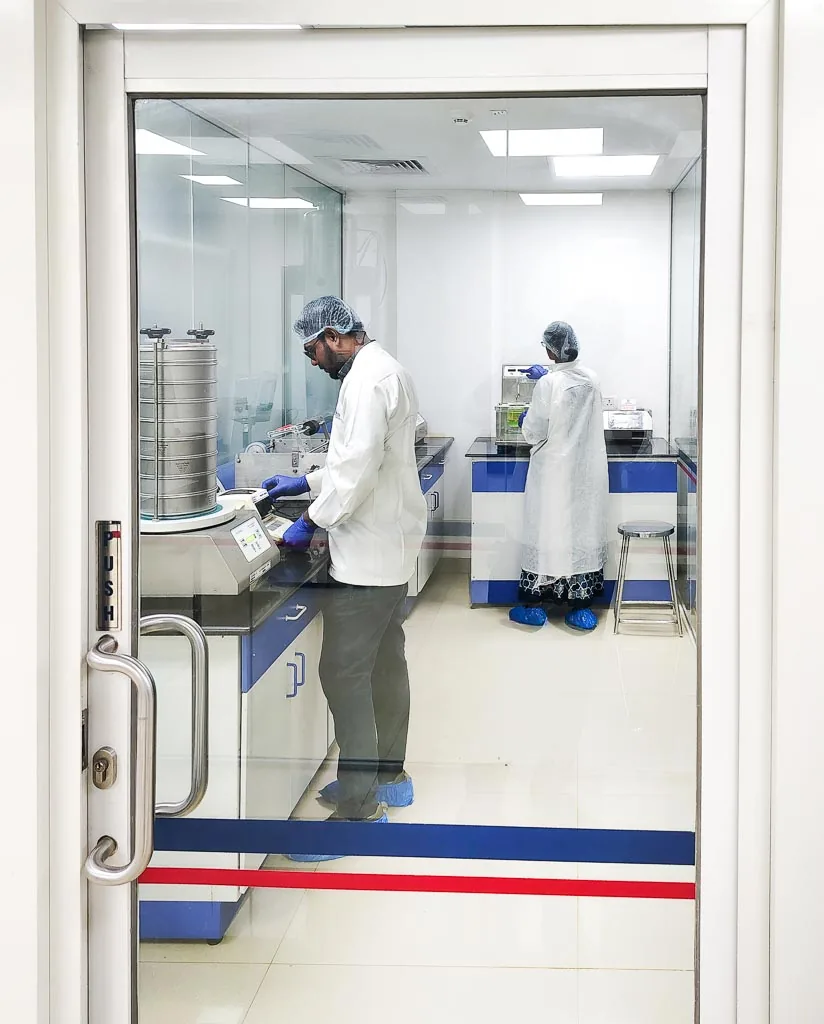 Analysts working with a sieve shaker and analytical instruments inside the Stabicon quality-control laboratory