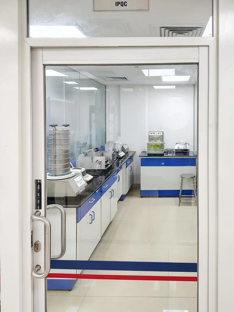 In-process quality control (IPQC) laboratory with sieve shaker and testing instruments at Stabicon