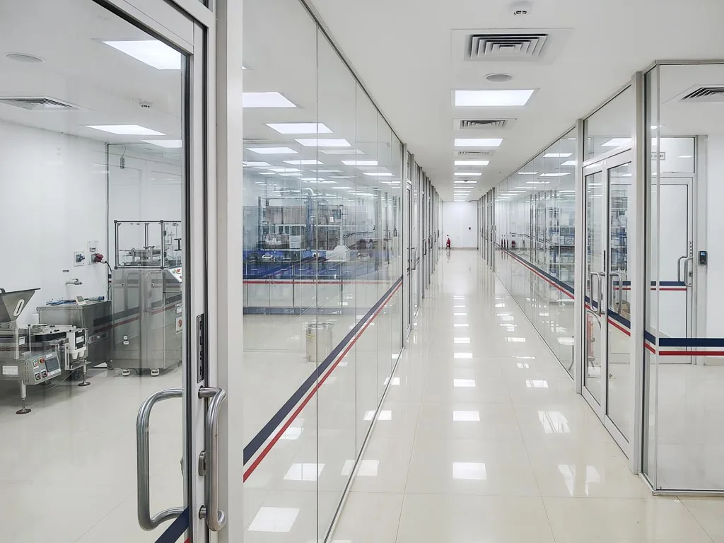 Glass-walled manufacturing corridor at Stabicon with production equipment visible through the partitions